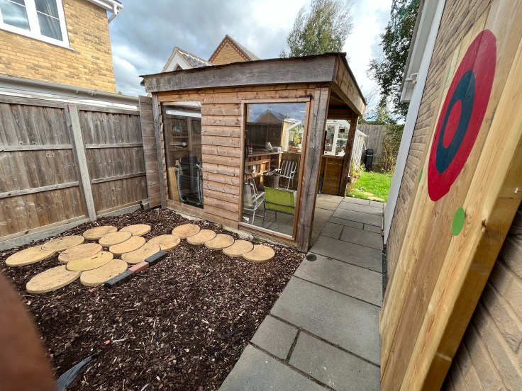 Side view of the throwing target and in the background the throwing patio and garden bar