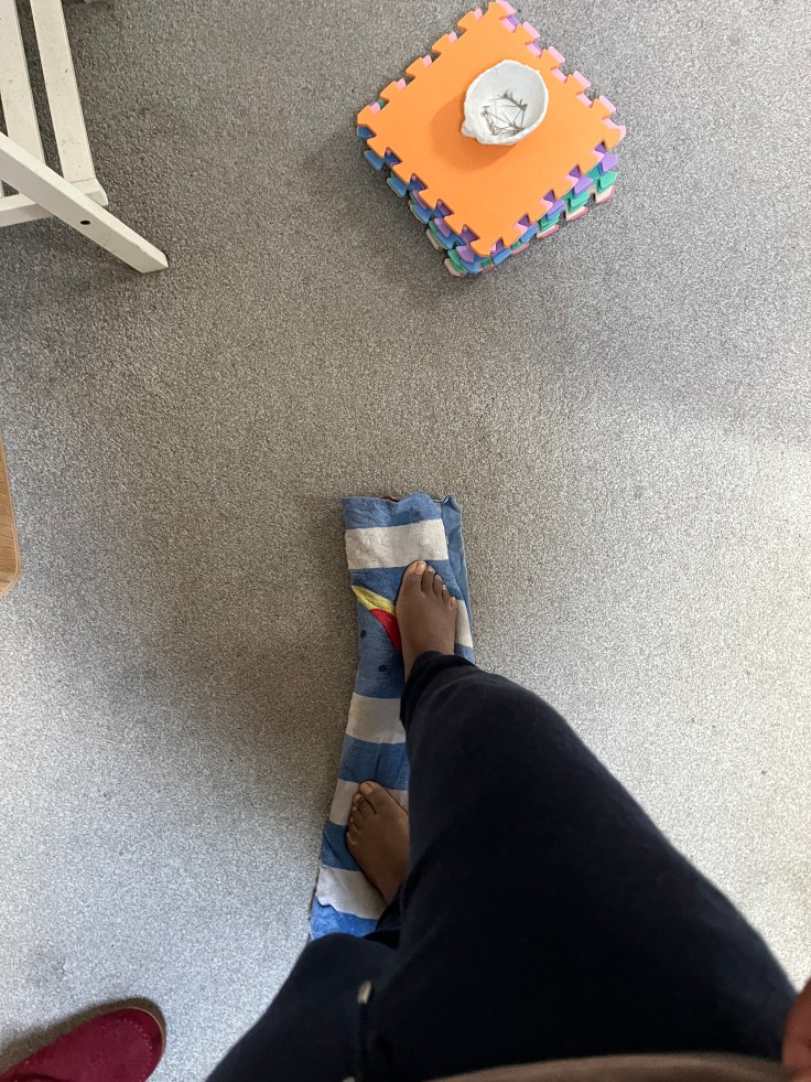 Standing on rolled up sweater in a towel